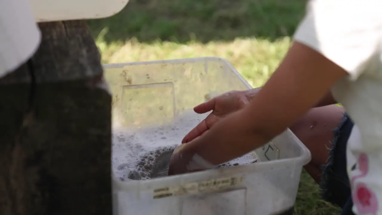 Child checking if hands are properly washed in the water