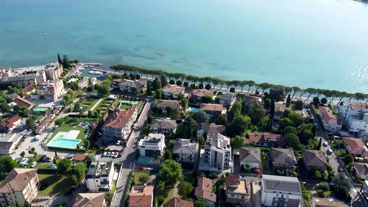 Enchanting houses and tranquil shores in Peschiera del Garda aerial tilt-up