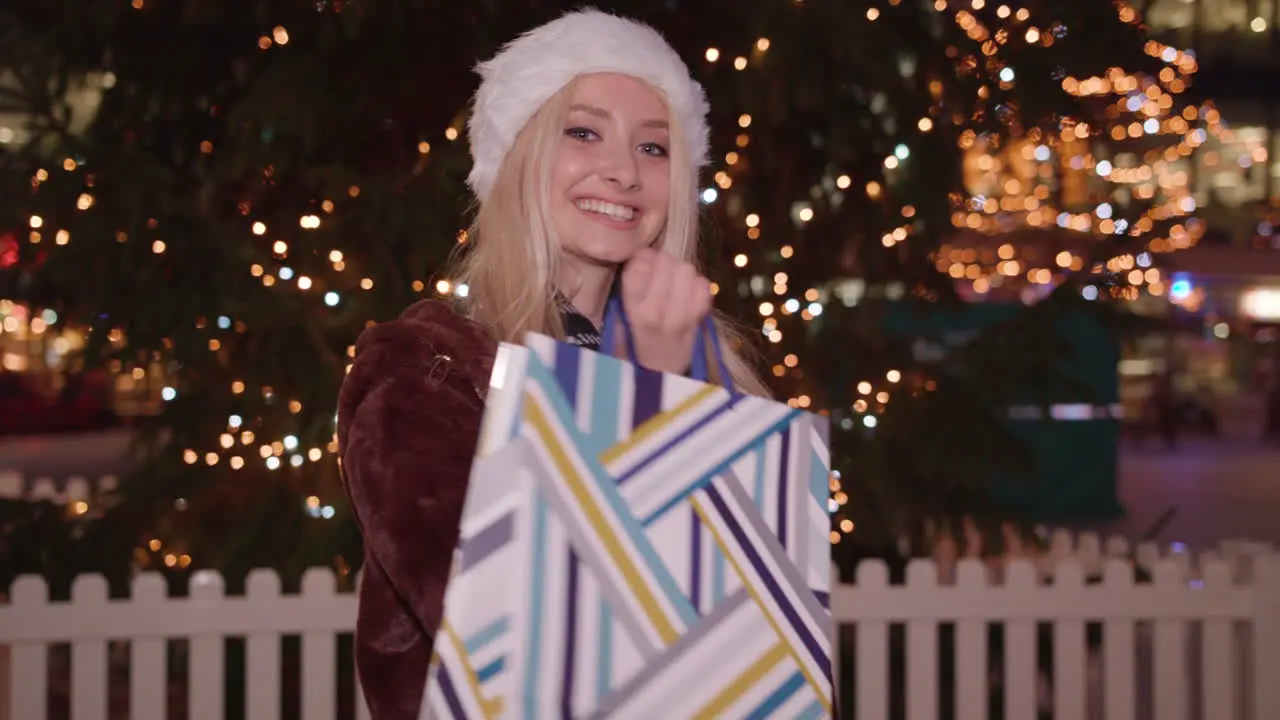 Young woman holds up her shopping purchase and twirls around and smiles