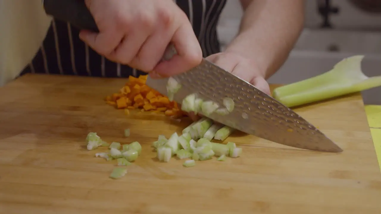 Chef cuts celery vegetable on wooden cut board