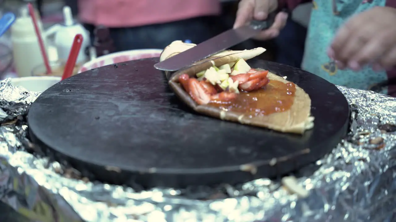 Putting fruit on a crepe