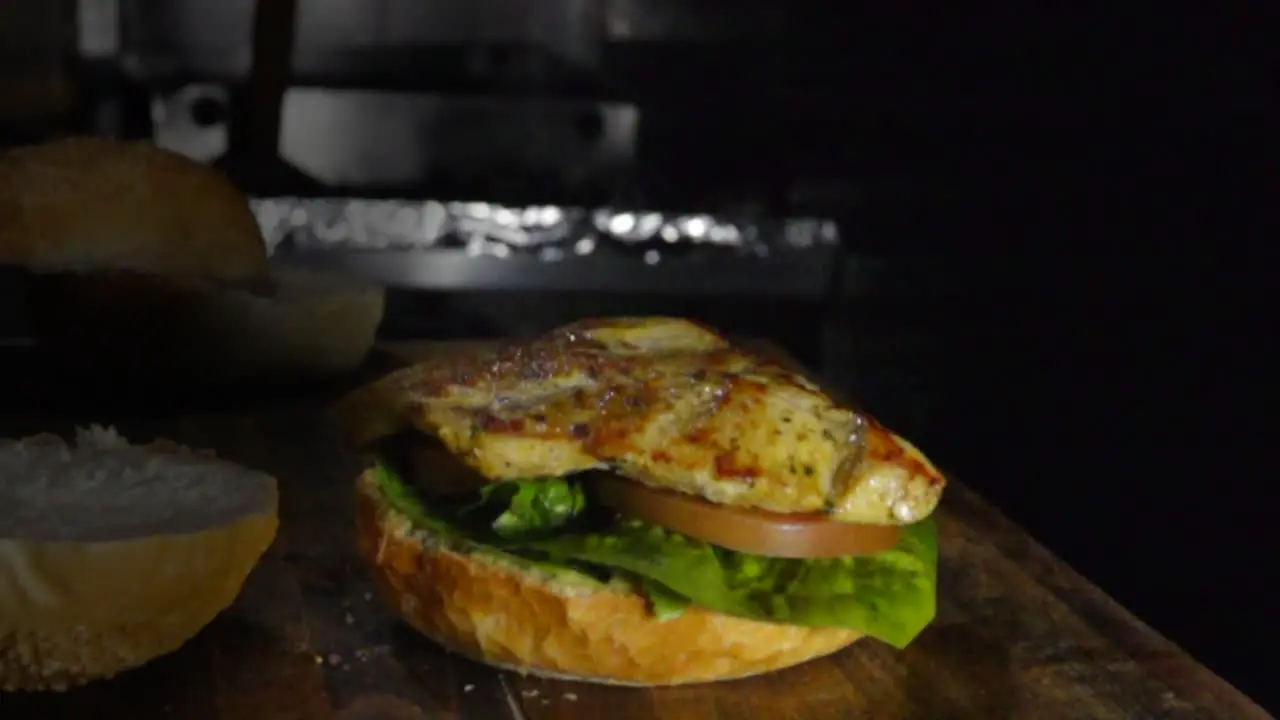 Grilled chicken breast falls on burger slow motion