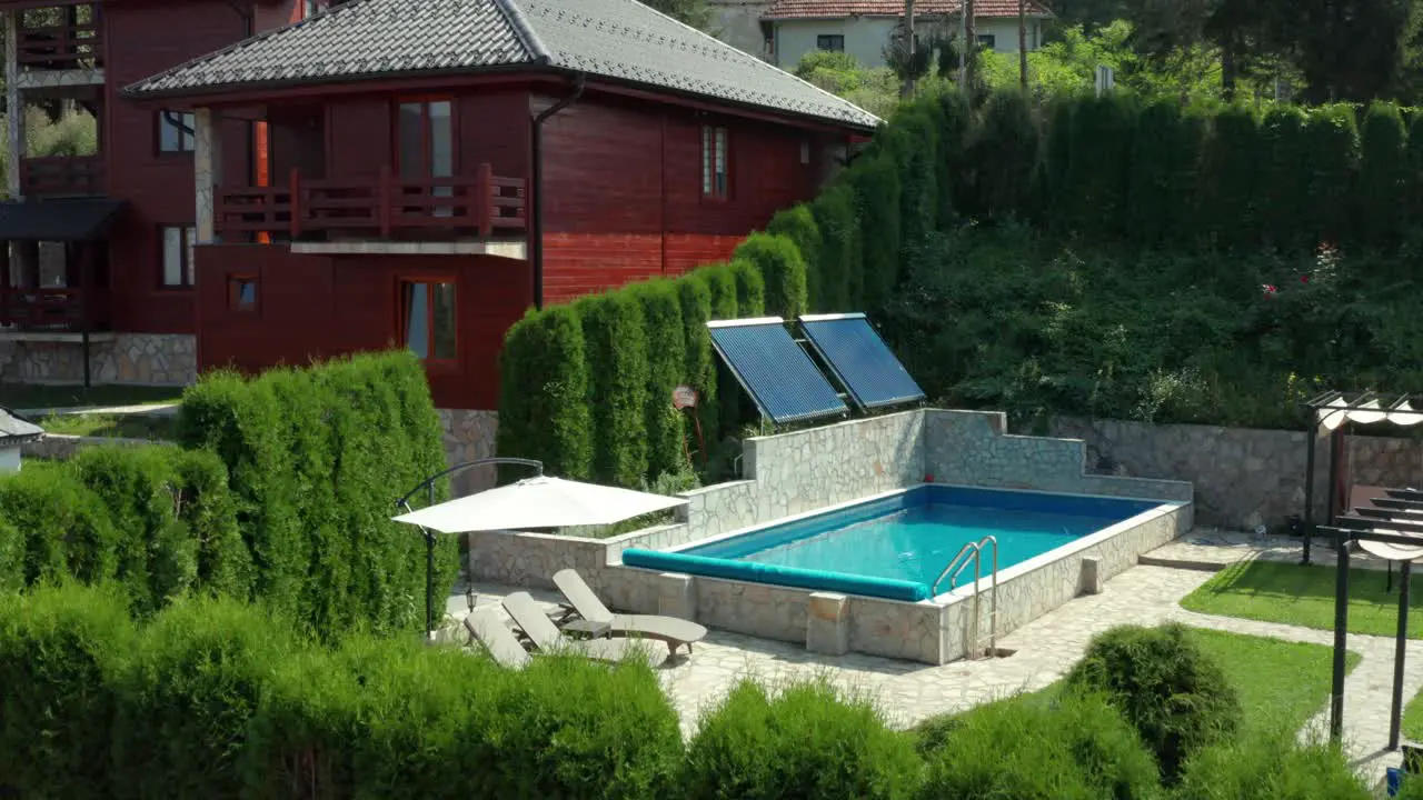 Beautiful holiday cabin villa and swimming pool in mountains rising aerial view