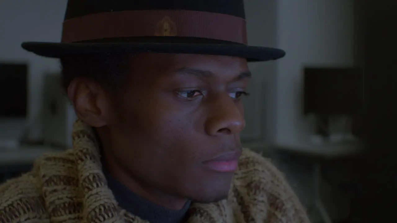 Man with black fedora hat Working On Computer In Studio close up