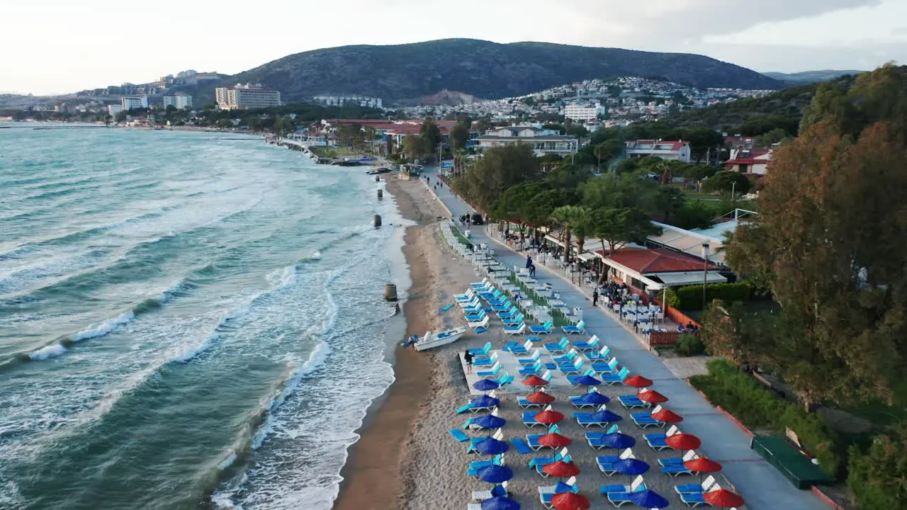 Resort on sandy beach with umbrellas at popular travel destination Kusadasi Turkey drone