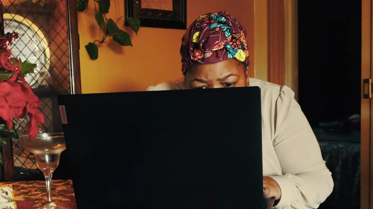 Black woman intently searching the internet on a laptop