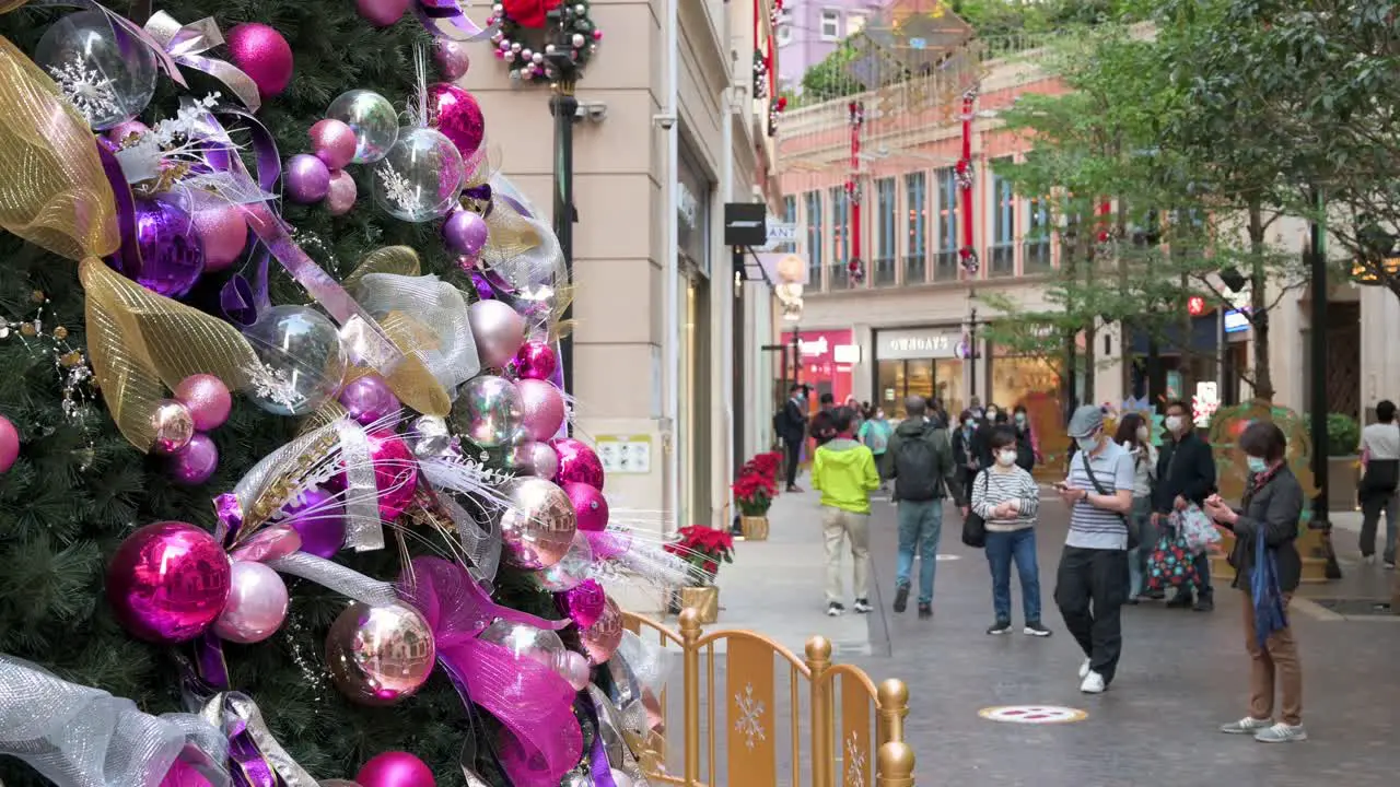 People take photos of a Christmas tree decorated with different shiny ornaments such as colorful balls and bows in Hong Kong