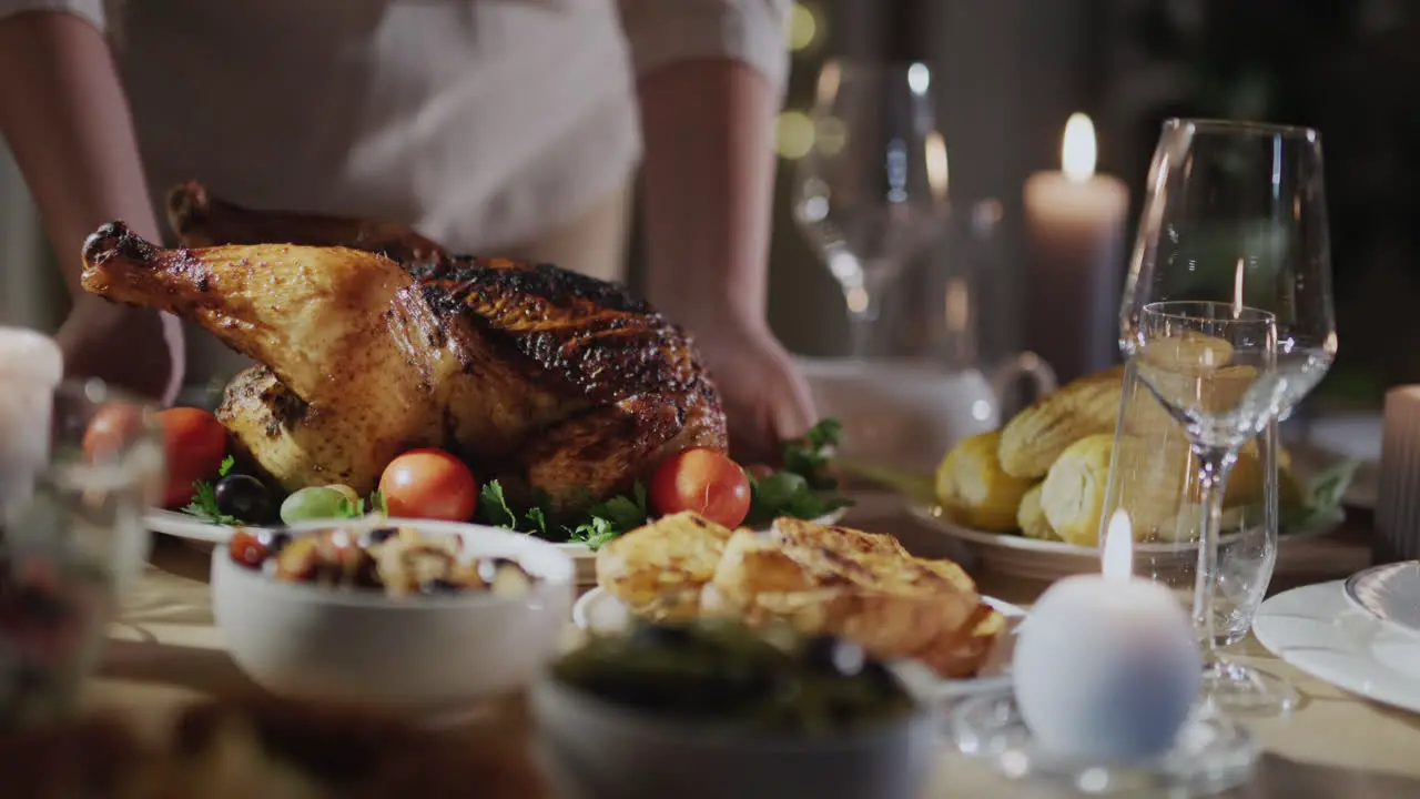 A woman serves a festive turkey on the table Thanksgiving Day celebration