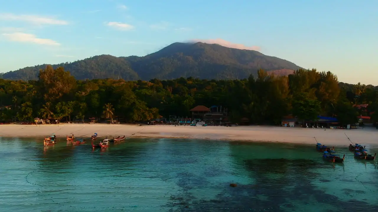 Shot of seaside from above using drone with white sand beach green trees and mountain in the background