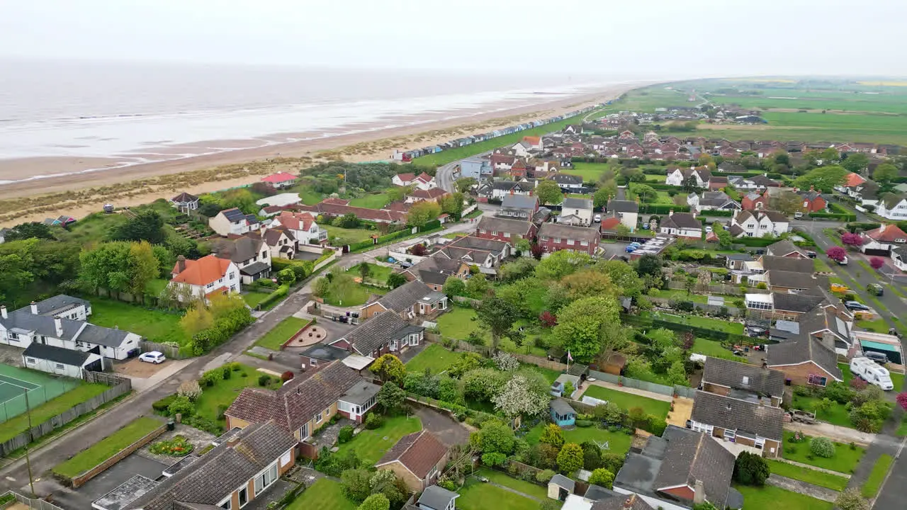 Marvel at Mablethorpe's seaside landscape in aerial footage featuring beach huts sandy beaches amusement parks rides and the bustling tourists