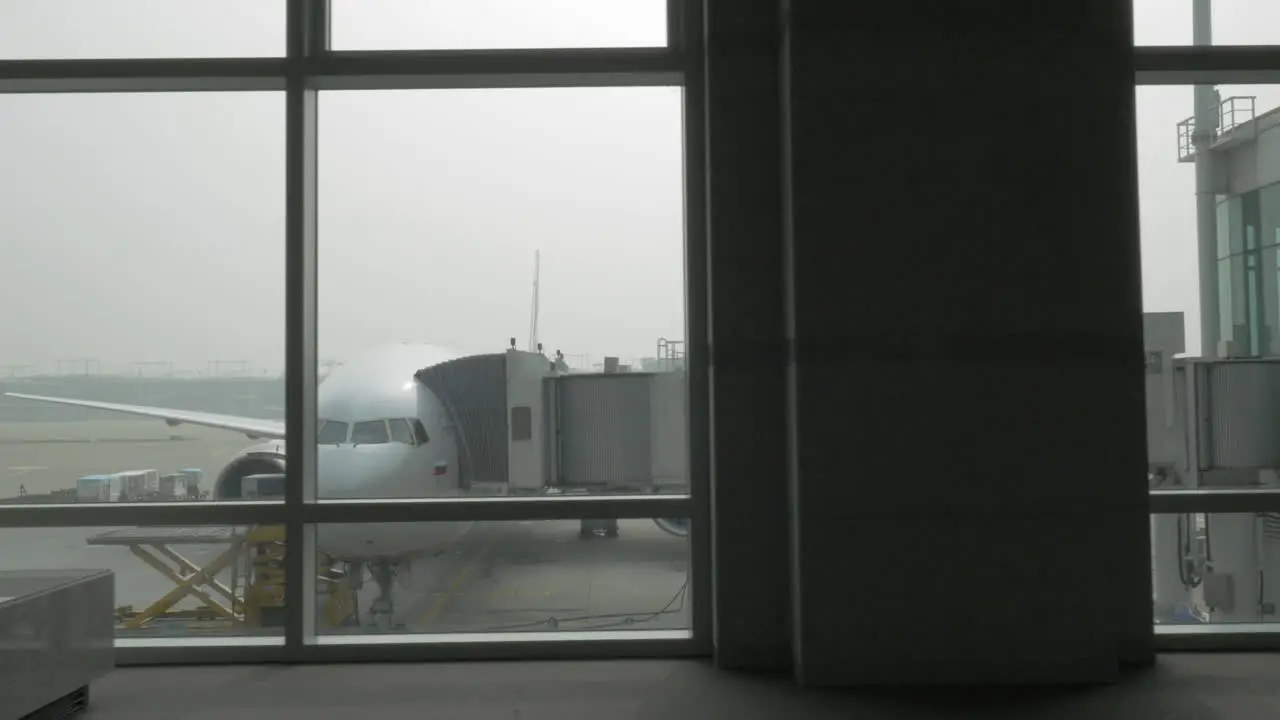 Unloading the plane with attached air bridge view from the window