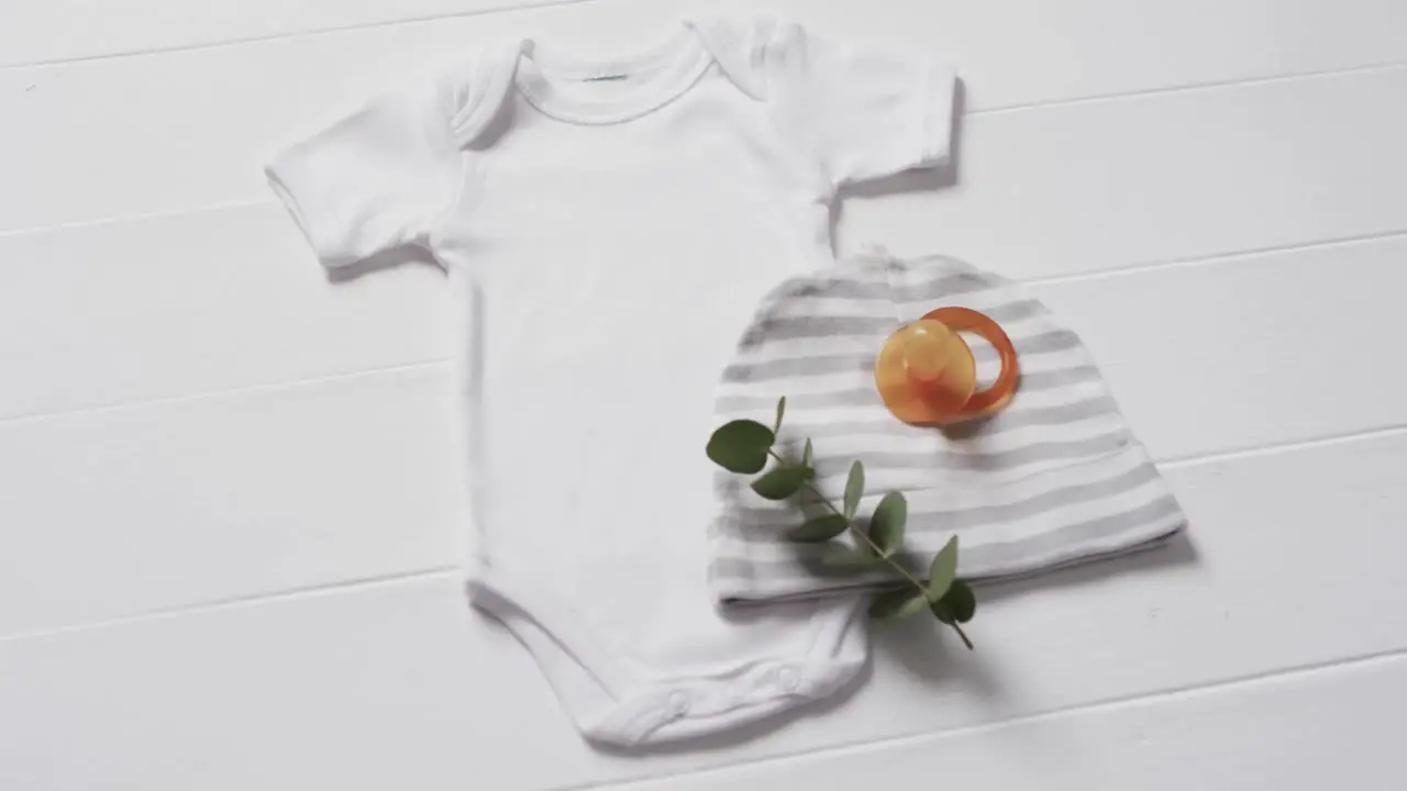 Video of white baby grow hat and dummy with copy space on white background