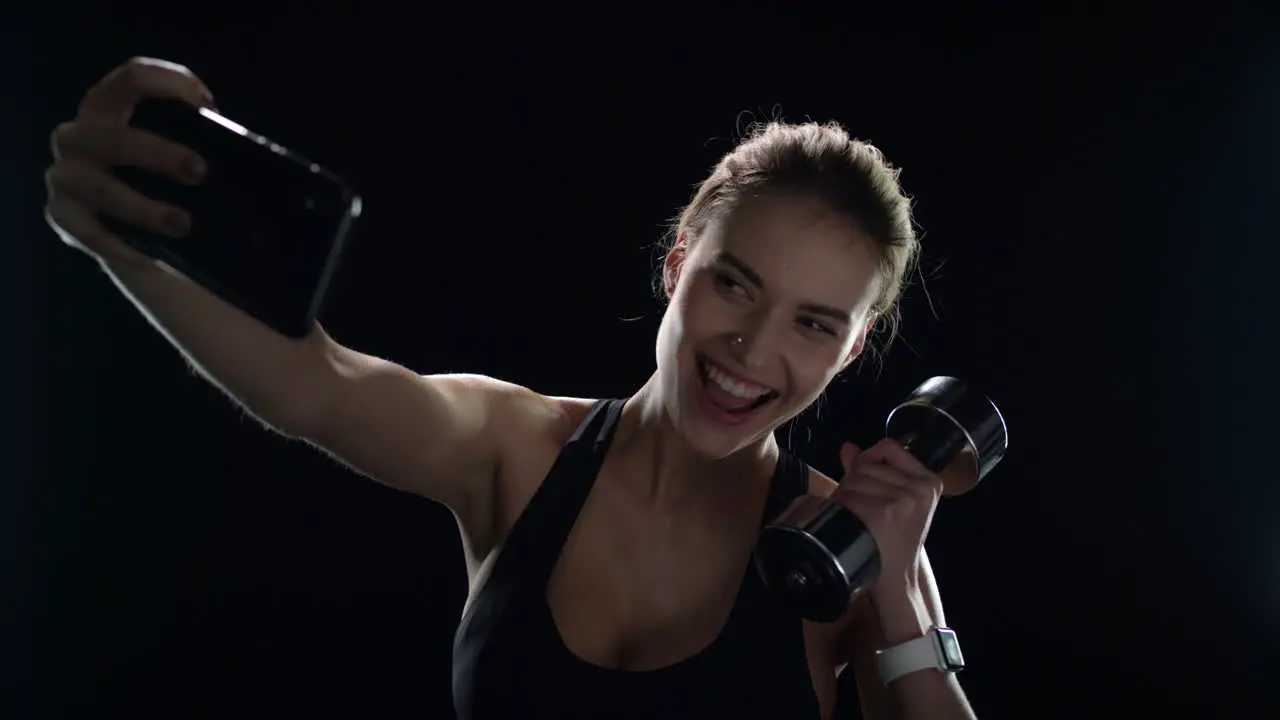 Sport woman taking selfie photo with dumbbell