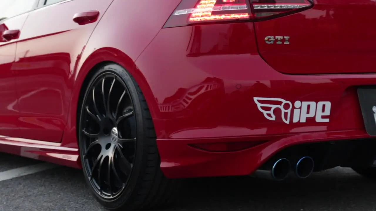 Close up of hot rod red Volkswagon GTi with modified exhaust car parked in a car park