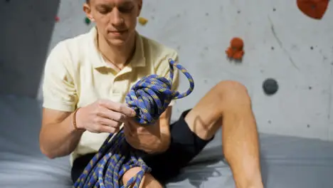 Man sitting in a climbing wall centre