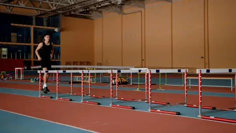 Male athlete jumping hurdles