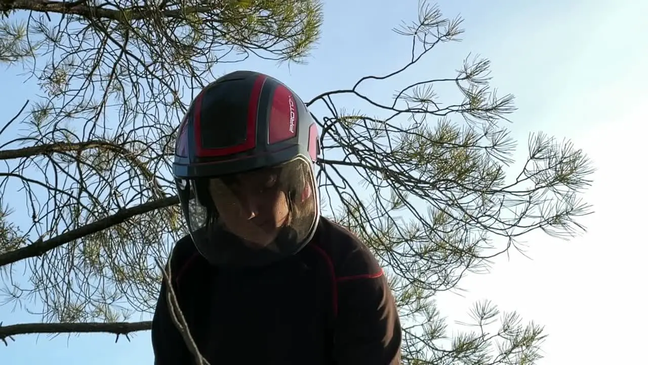 Lower angle of a 30 years old woman wearing a helmet with a transparent visor special for chainsawing