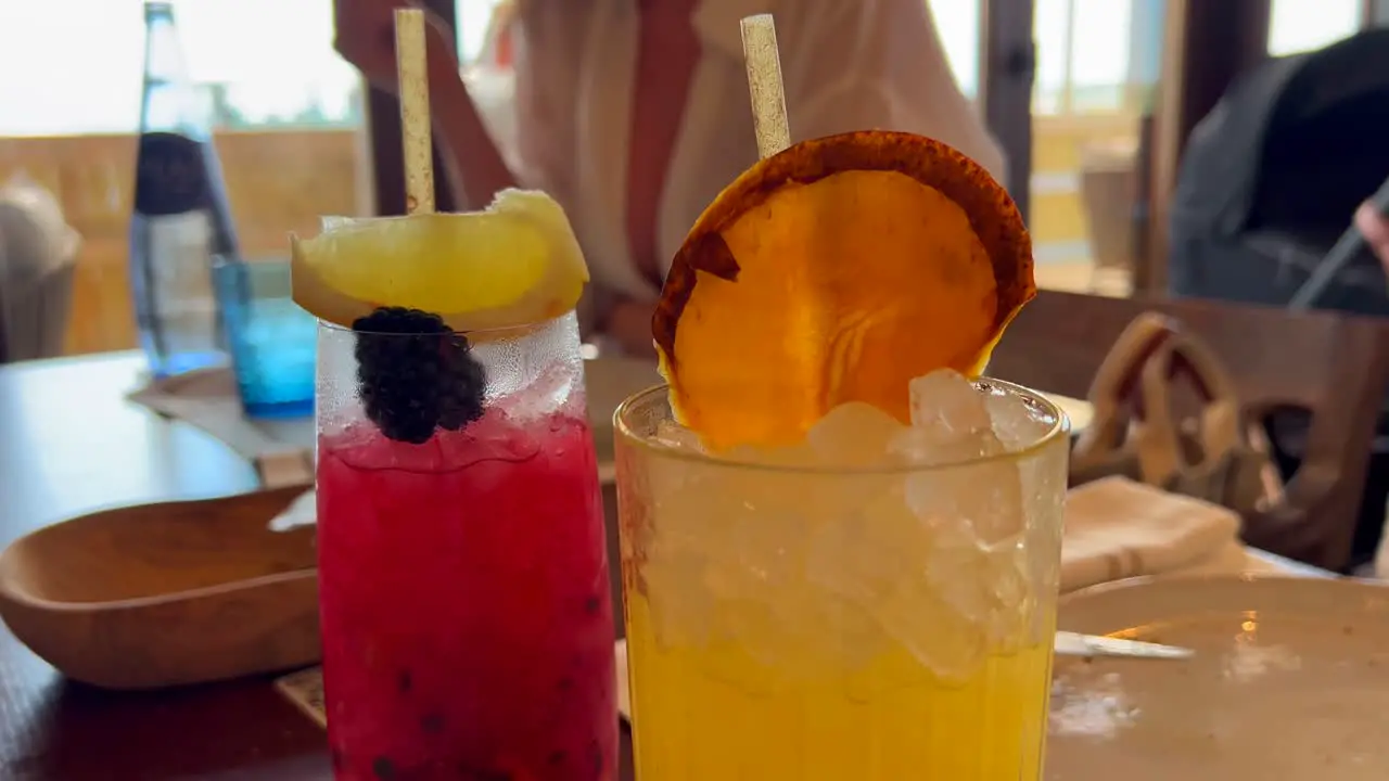 Picking up a delicious summer fruity cocktail in a restaurant enjoying cold refreshing drinks at a bar 4K shot