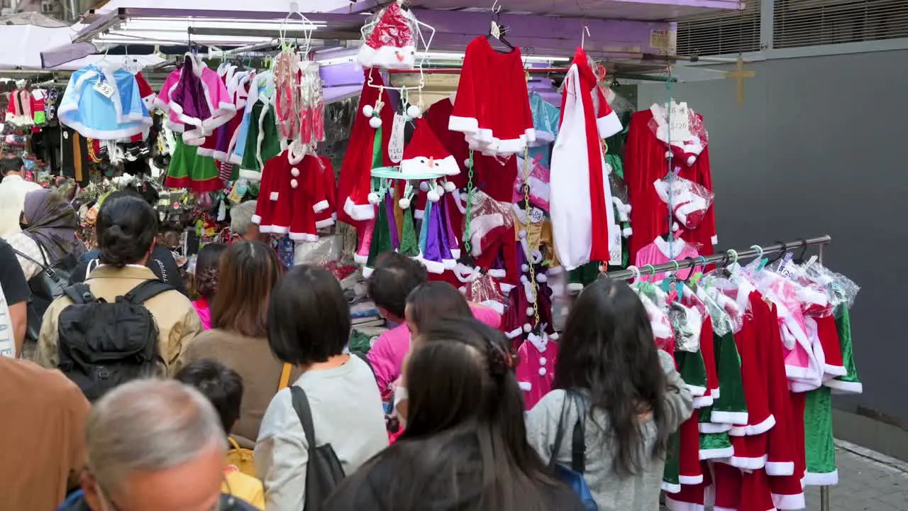 Pedestrians walk past a street stall selling Christmas merchandise such as hats ornaments and costumes in Hong Kong