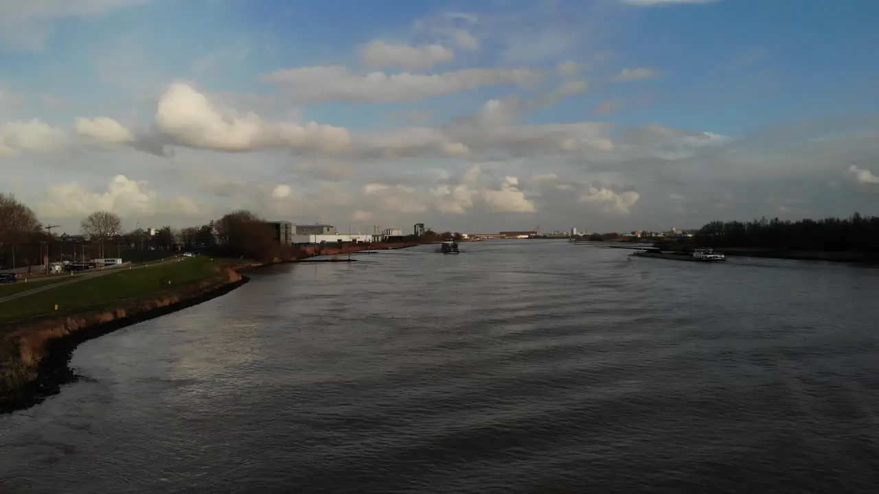 Scenic View With Cargo Vessels Sailing Across Quiet River Of Oude Maas In The City Of Zwijndrecht Netherland