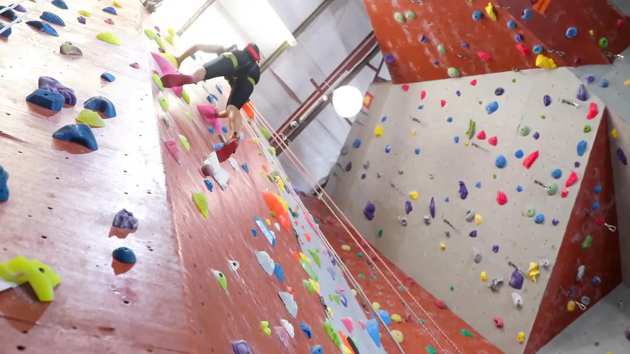 Low angle of woman practicing bouldering 4k