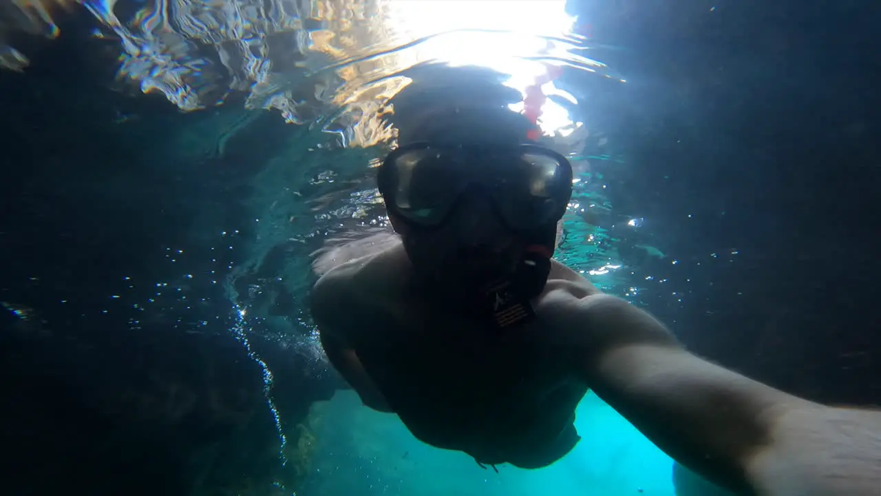 Selfie view an adult is swimming underwater in