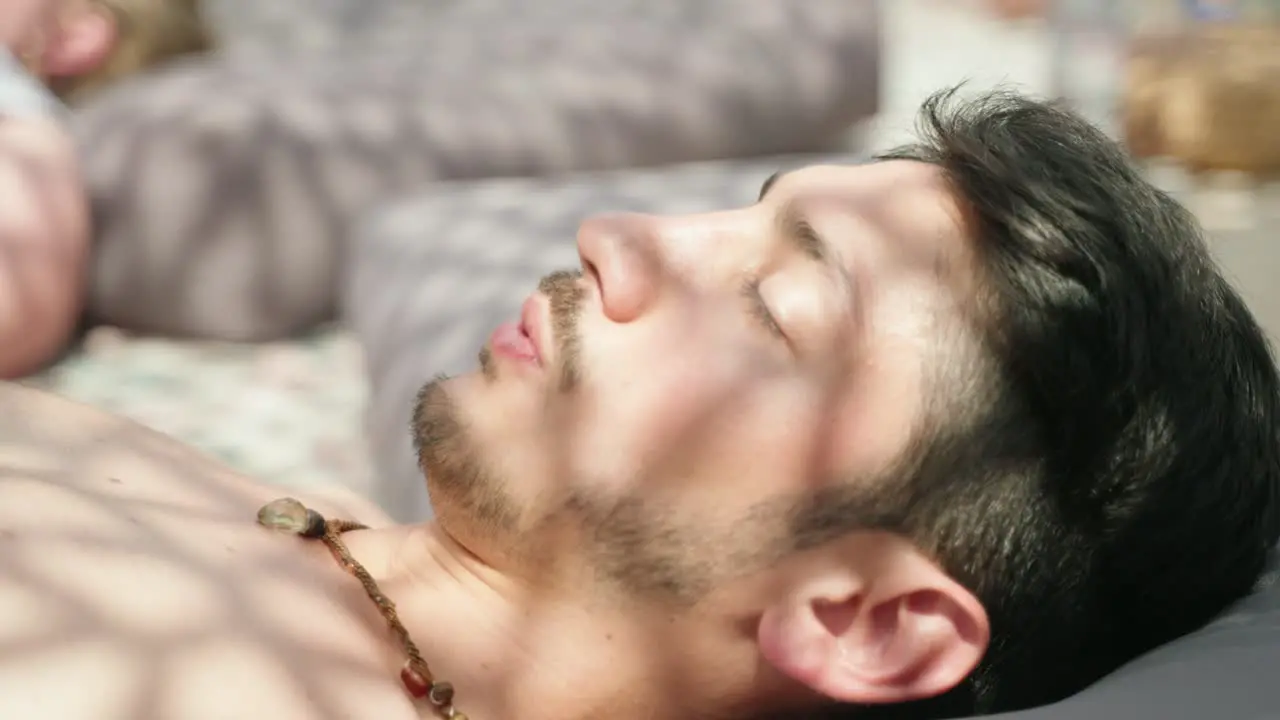 Closeup of a young beautiful man doing breathwork with his eyes closed