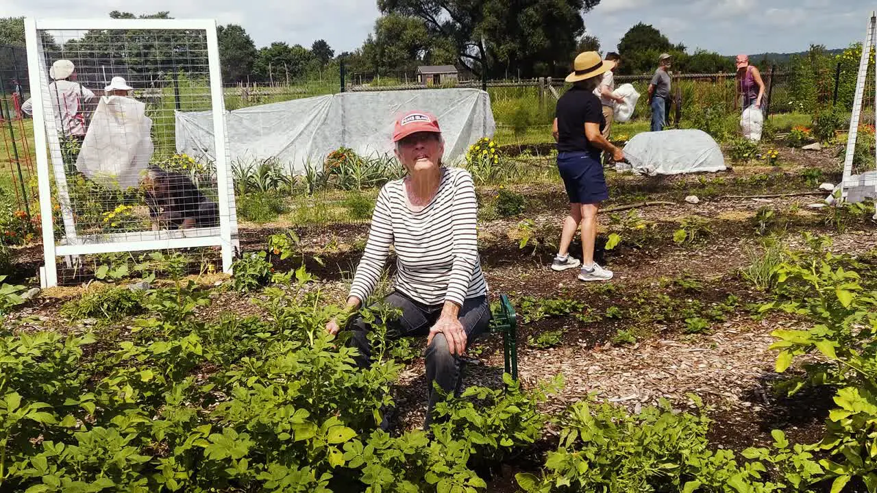 Woman talking to cameraman in community garden