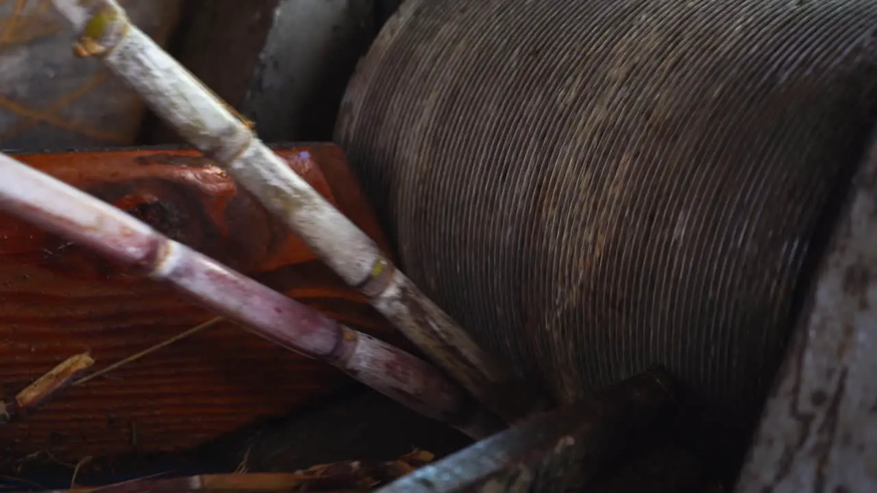 Sugar Cane being squeezed by a sugarcane squeezing machine