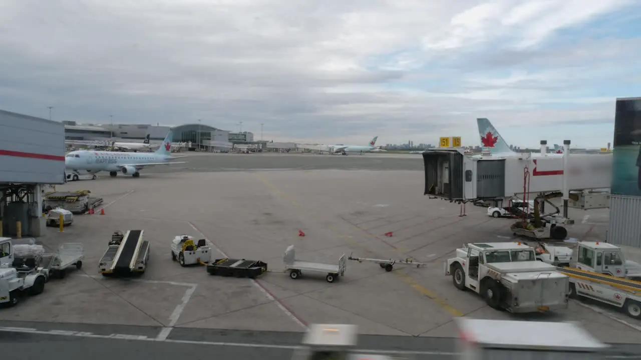 Airplane approaches airport gate while various vehicles drive around