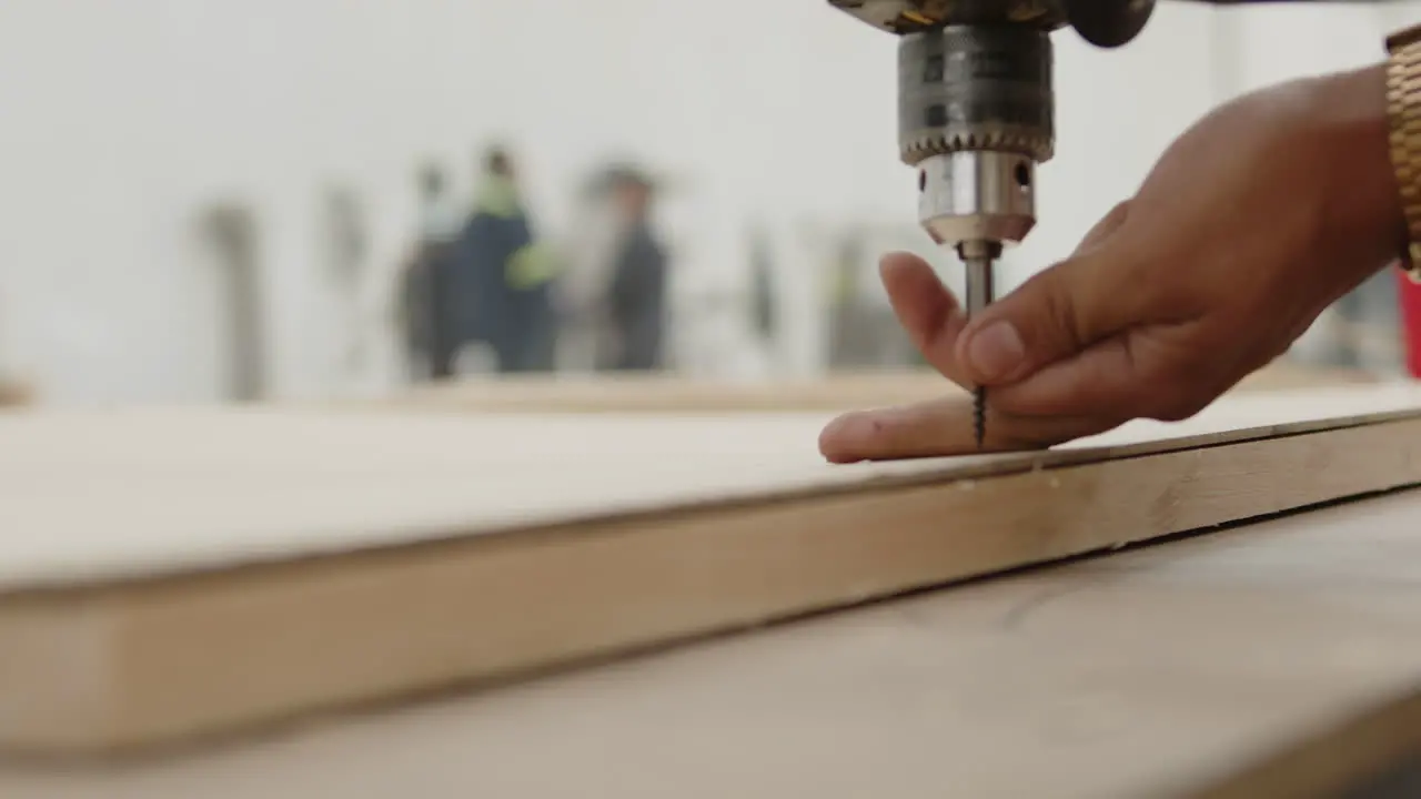 Men drilling a piece of wood