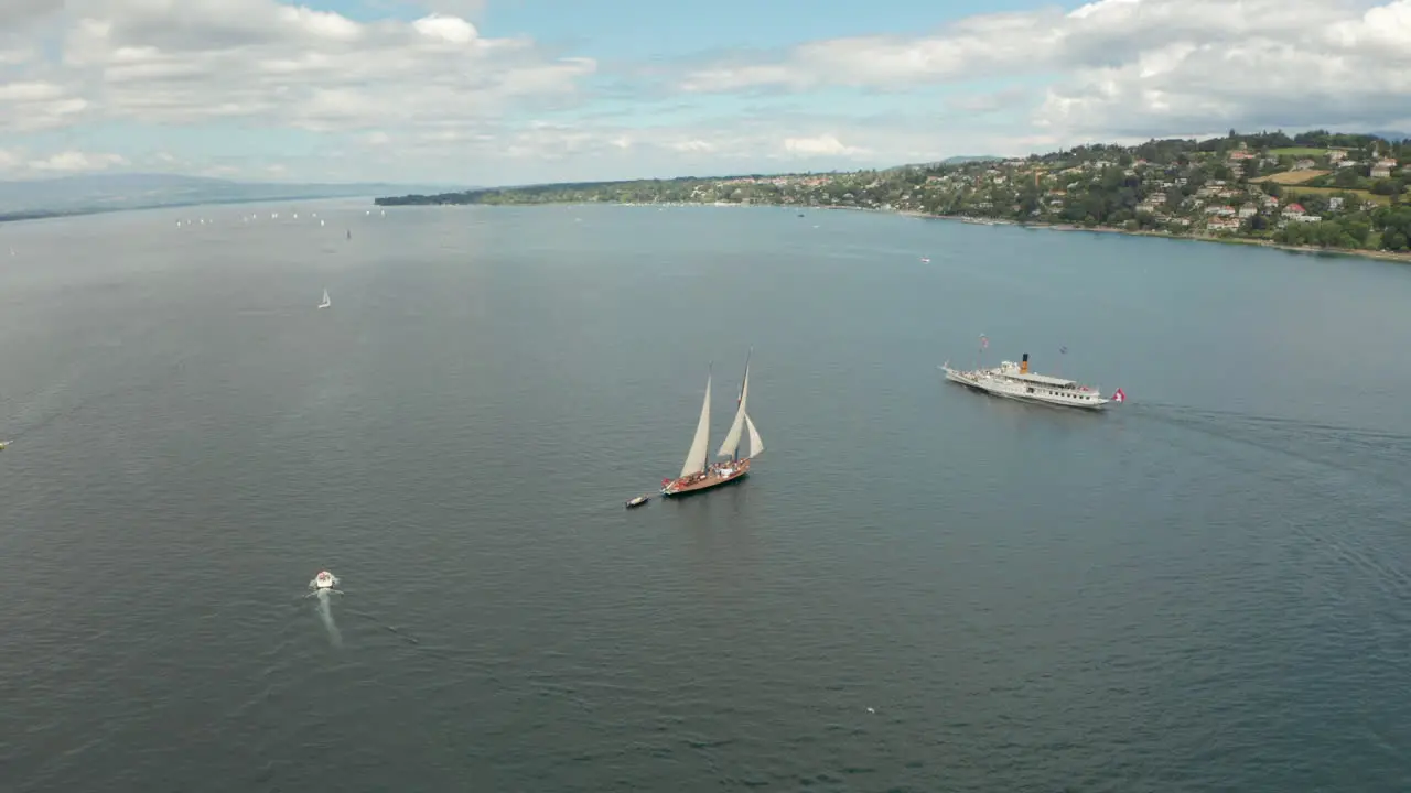 Circling aerial shot around a sail boat to reveal Geneva city