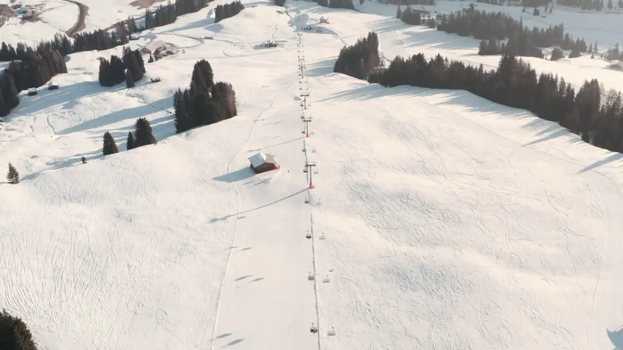 follow drone shot of lone skier on a long ski slope