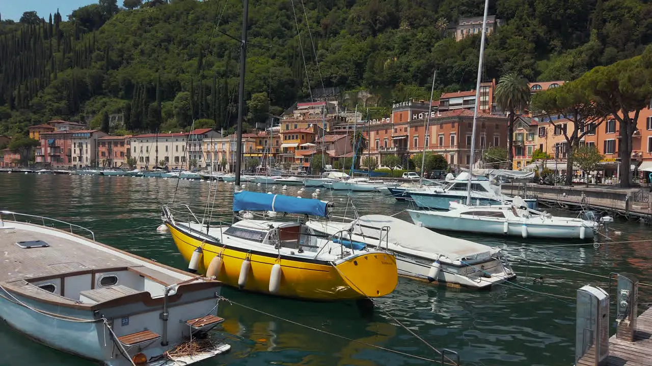 Horizontal pan of a boat harbor at Lake Garda revealing the beautiful coast line in summer