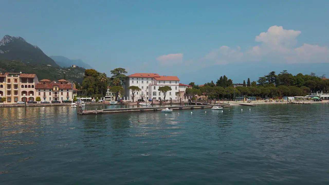 Tracking shot of the coast line at Lake Garda revealing the scenic mountains