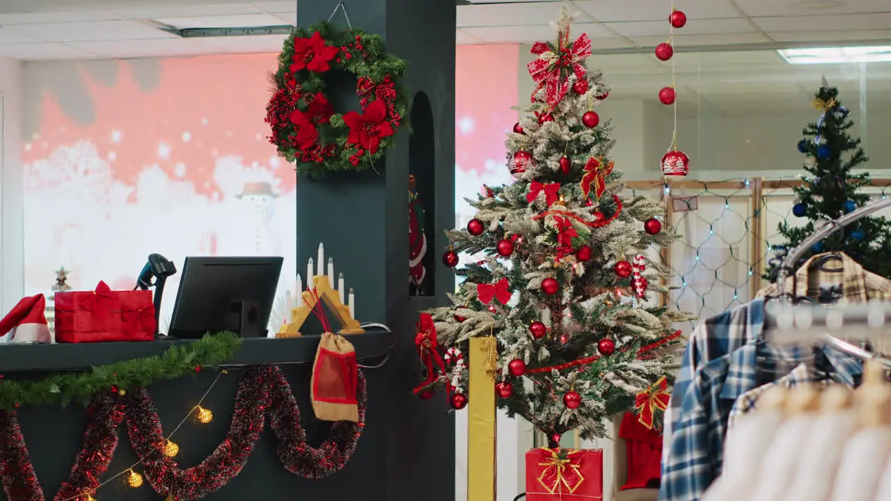 Beautifully decorated Christmas tree in clothing store ready to spread holiday cheer to visiting customers looking to buy presents Xmas adorn fashion boutique in mall during winter holiday season