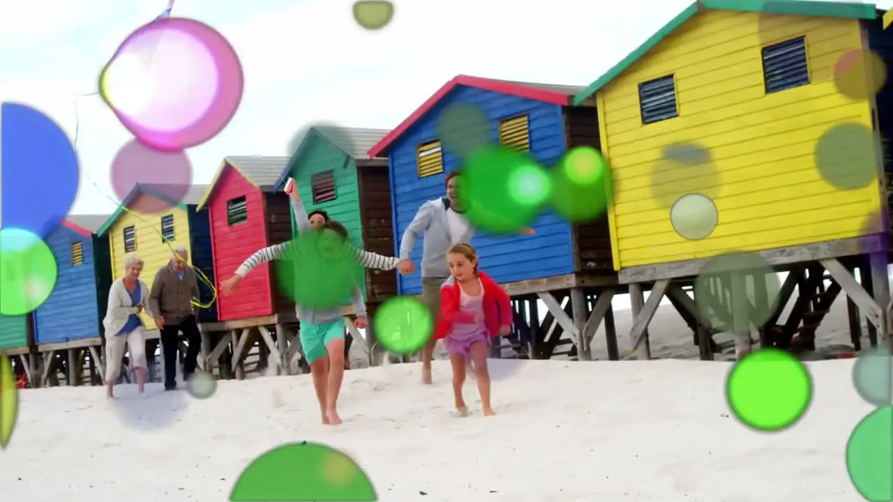 Moving spots of coloured light with family on beach