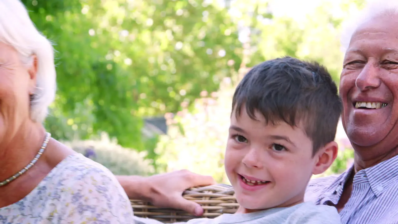 Three generation family relaxing in the garden close up