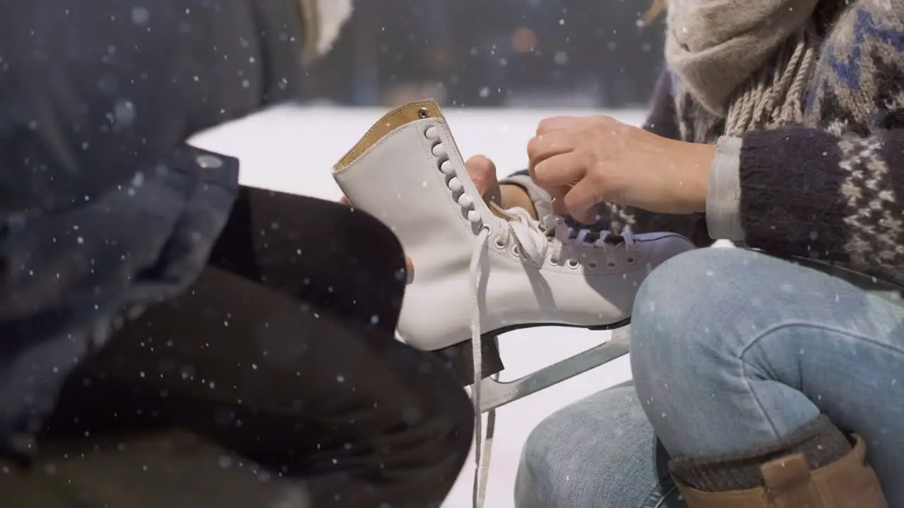 mother helps daughter undoing skates