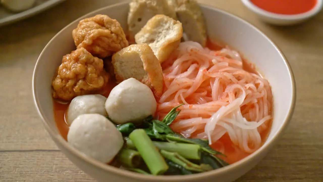 small flat rice noodles with fish balls and shrimp balls in pink soup Yen Ta Four or Yen Ta Fo Asian food style