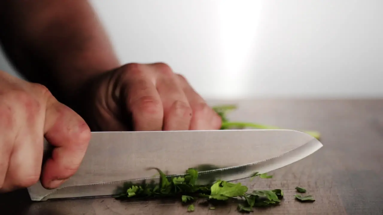 Professional chef cutting parsley on wood chopping block