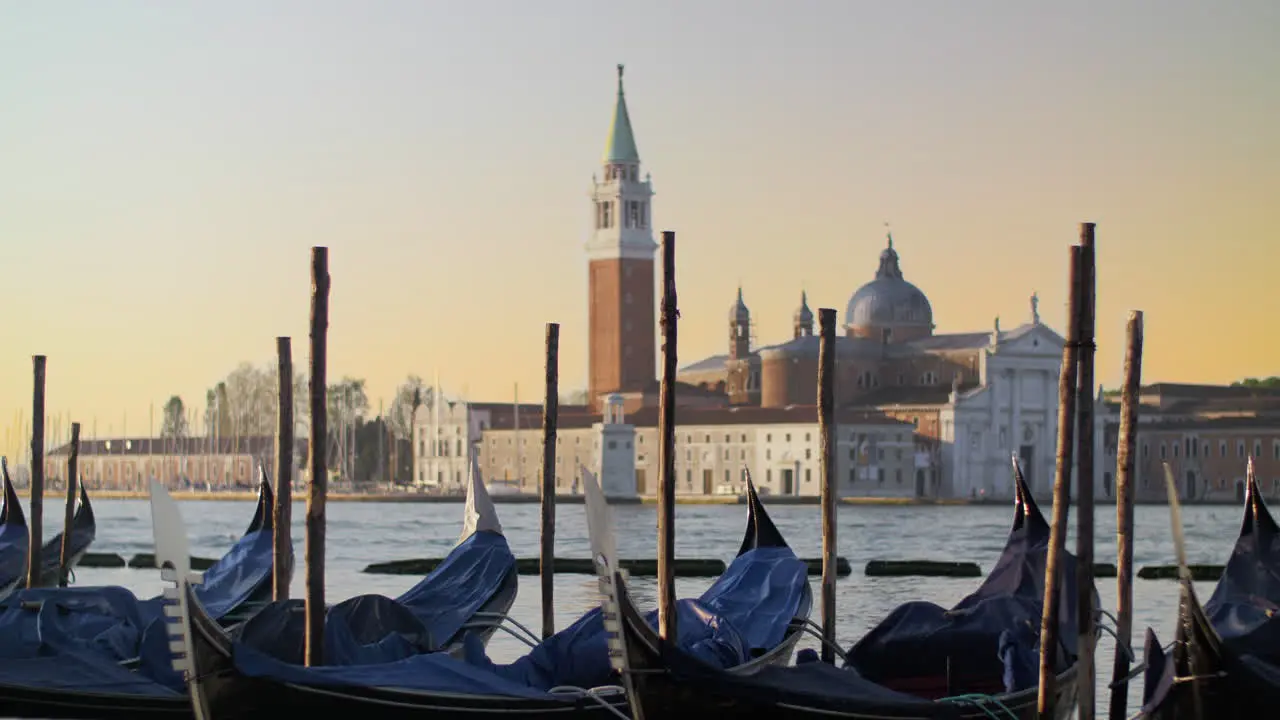 Covered gondolas swaying on water against a beautiful Venice view