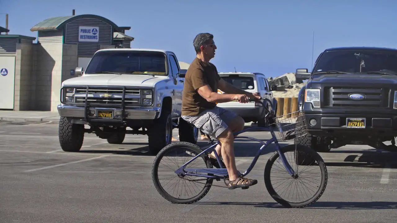 Man Cycling Through Car Park