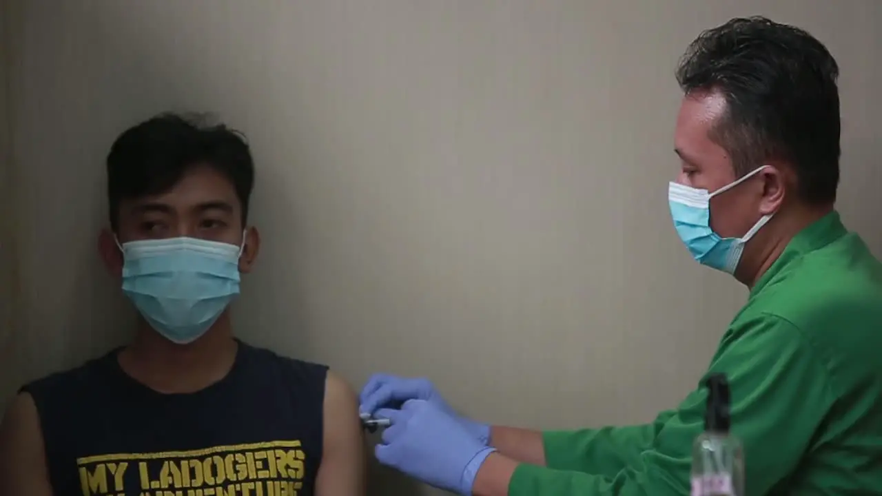 Close up of a Doctor making a vaccination in the shoulder of patient Flu Vaccination Injection on Arm coronavirus covid-19 vaccine disease preparing for human clinical trials vaccination shot