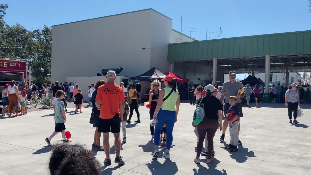 Huge Crowd of People at an Open House Fire and Safety Demonstration Event at the Fire House with Fire Truck and Ambulance on display for the public to see Tampa Florida Panning Shot