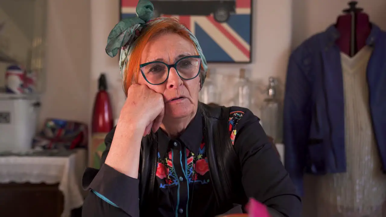 An modern trendy older lady sitting talking in a home setting