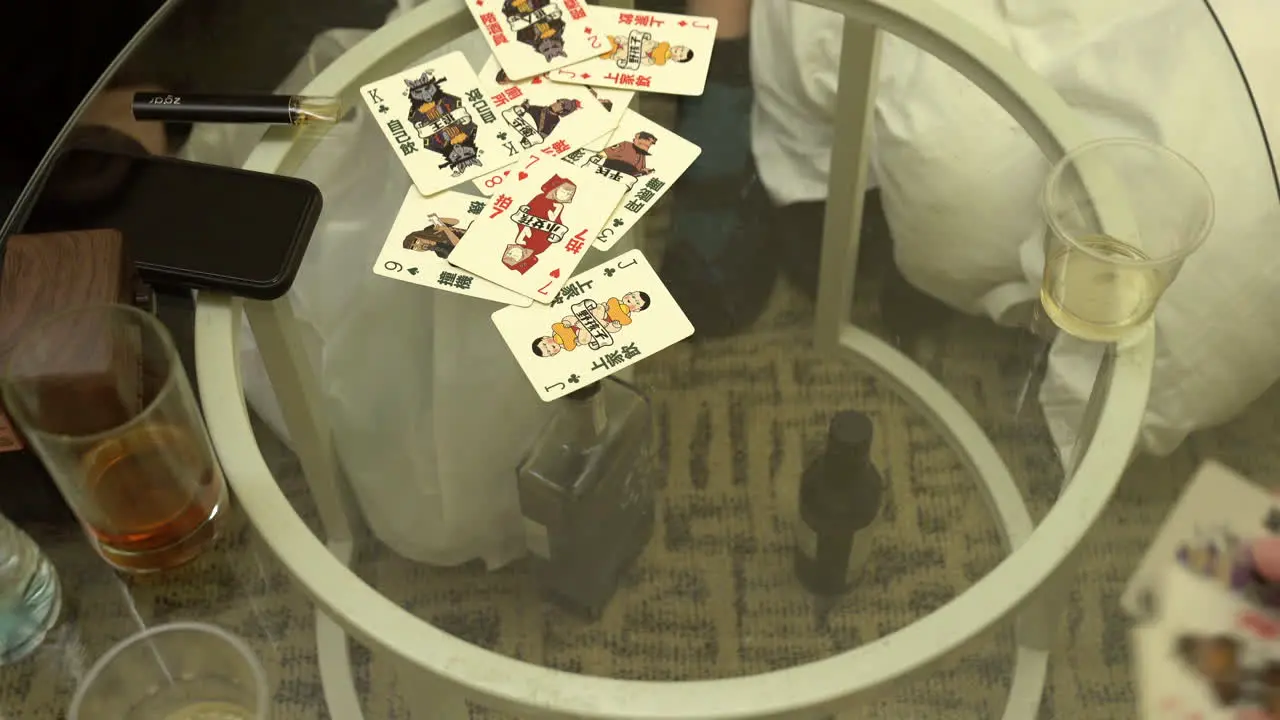 People playing a typical card game in hong kong on a glass table