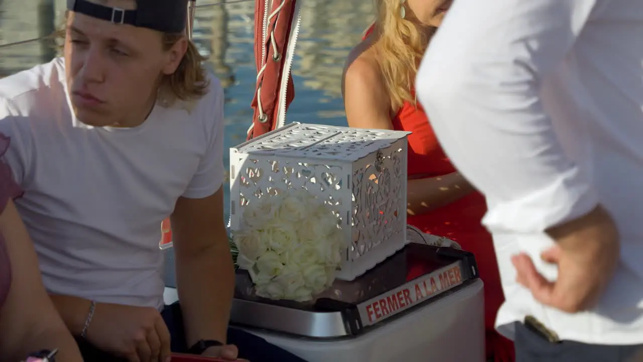 Teenager talking to someone while sitting on the side of a sailing boat