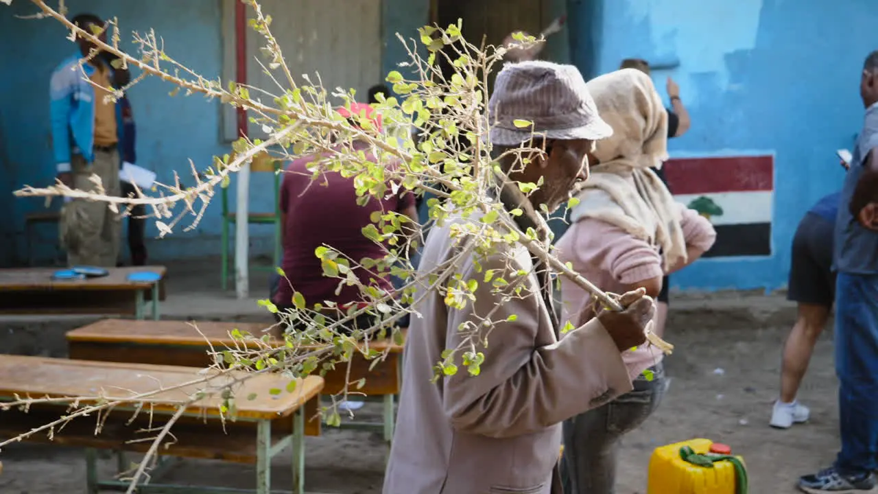 Old local Ziway man walks around a group of people working on restoring school in Ziway Ethiopia during a charity event