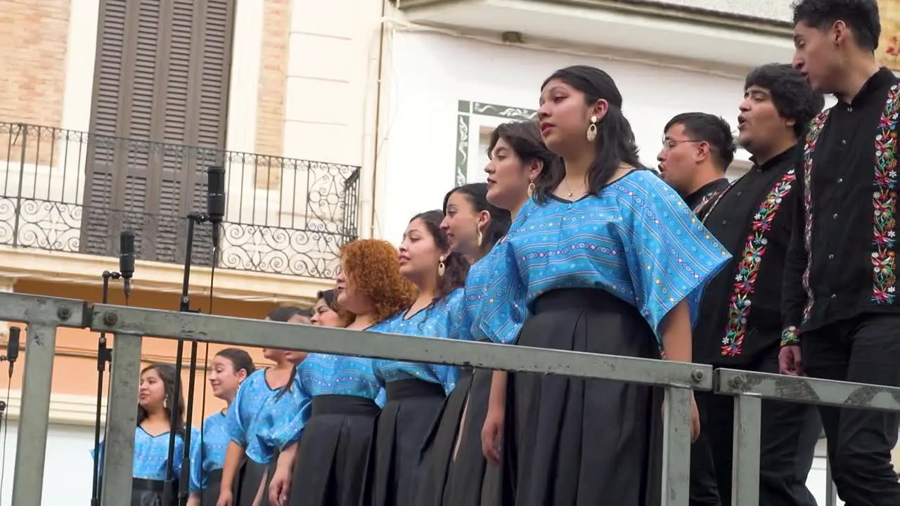 Side view of choir group singing on stage in a city square